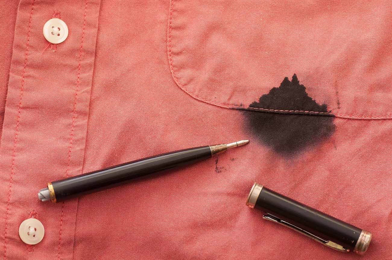 Camisa vermelha masculina manchada com tinta de caneta