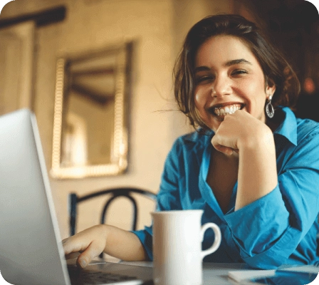 Mulher sorrindo enquanto digita em um notebook